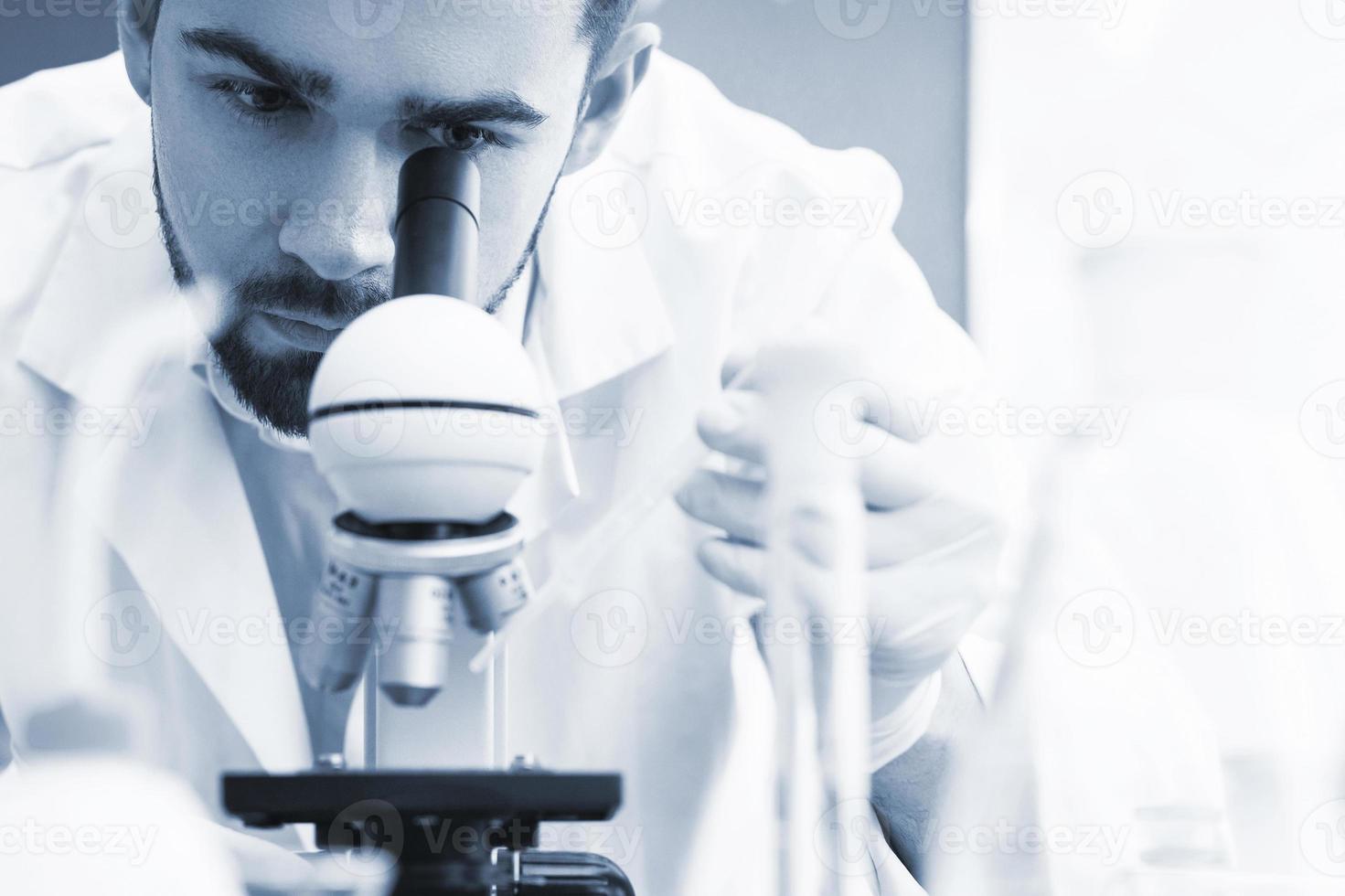 Scientist is using microscope in a laboratory during science research work photo