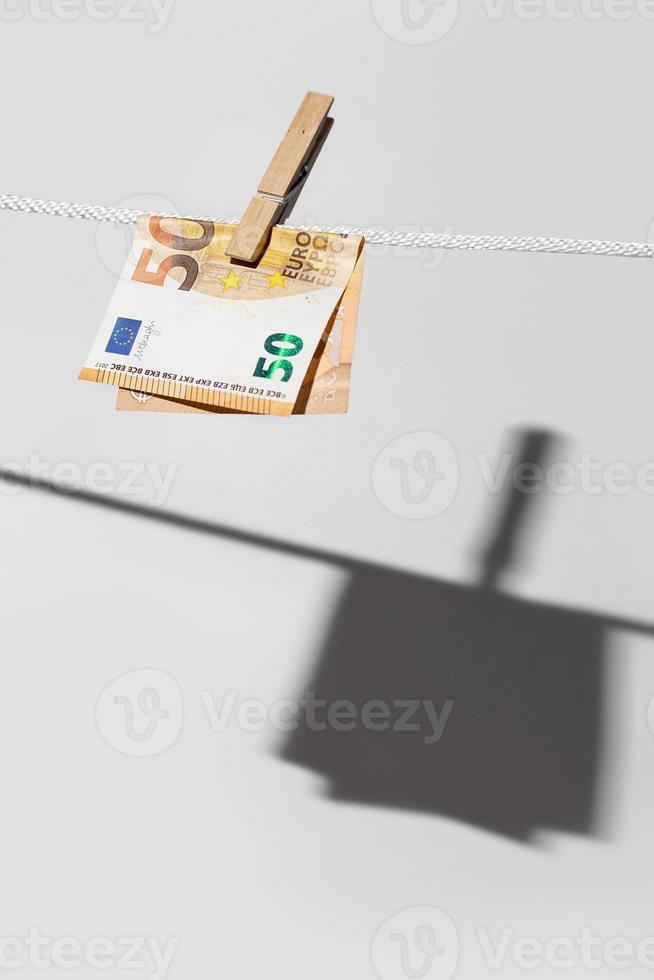 Euro banknote is hung on a rope with clothespin photo