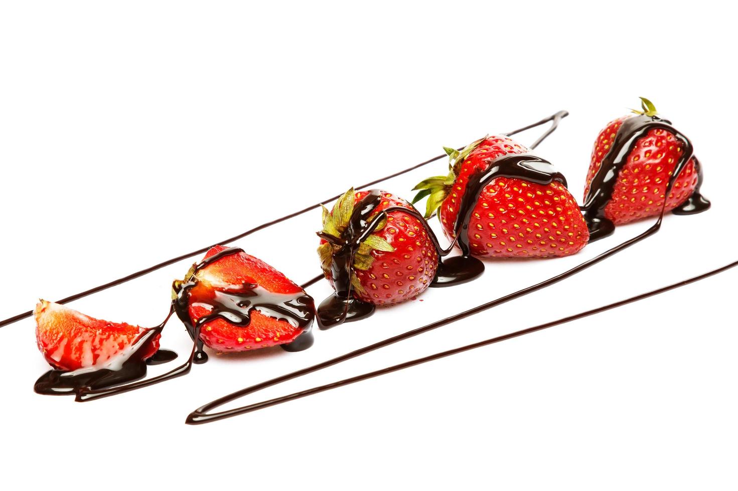 Strawberries covered with chocolate syrup on white background photo