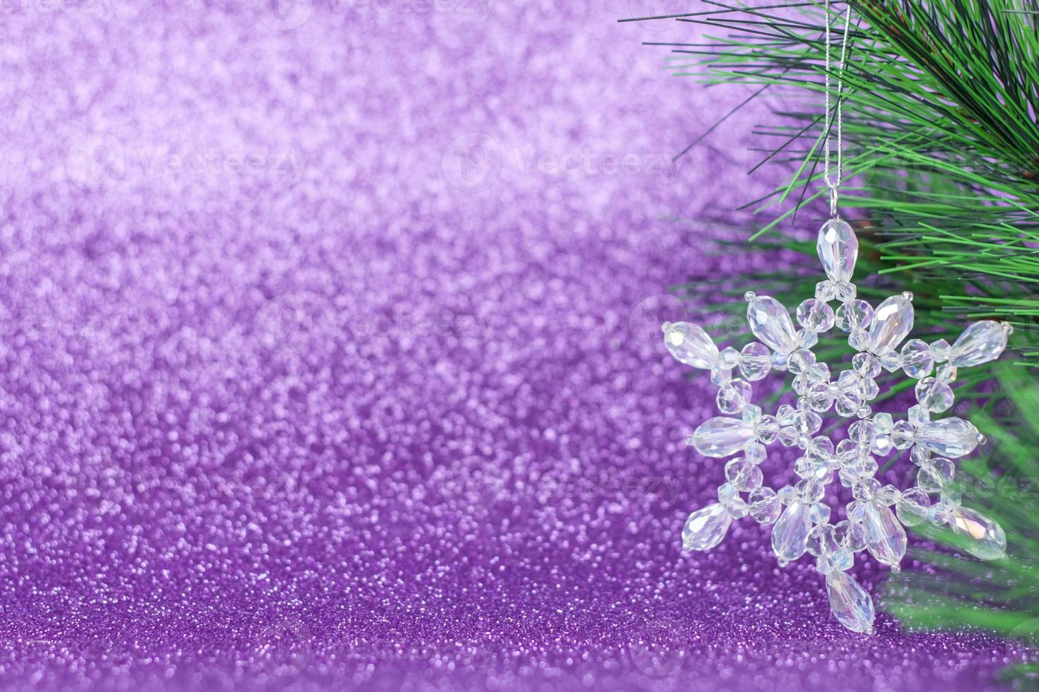 Crystal snowflake on the Christmas tree. Snowflake on a purple background. photo