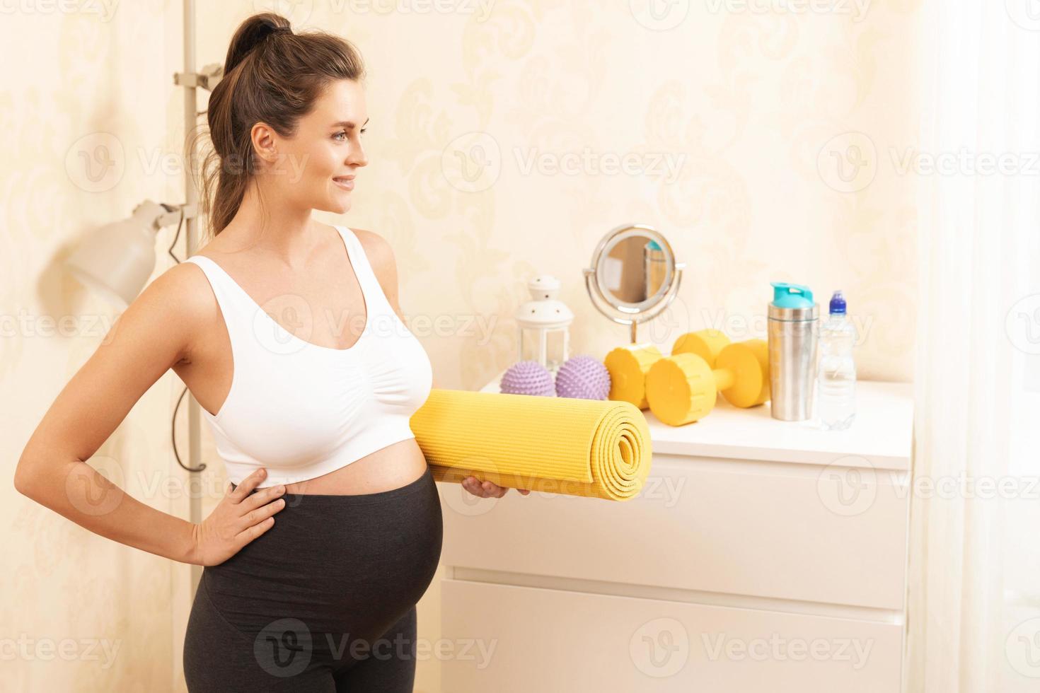 Pregnant woman during her fitness workout at home photo