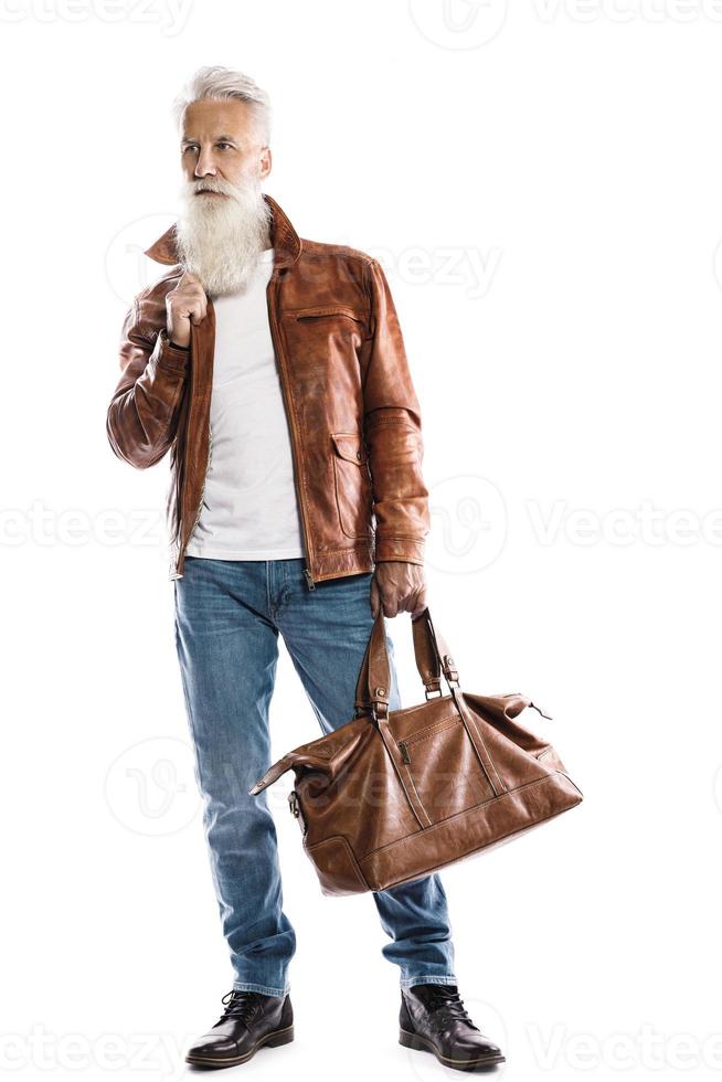 apuesto anciano barbudo con bolso de cuero y chaqueta de fondo blanco foto