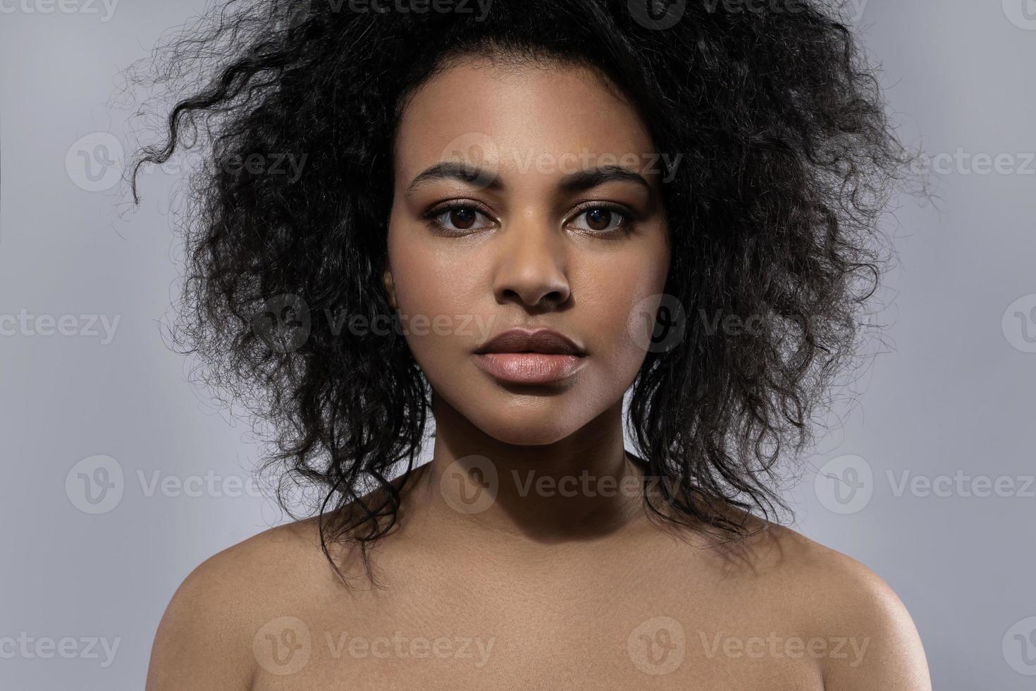 Beautiful black woman with smooth skin against gray background photo