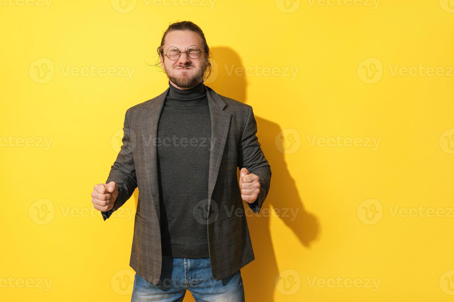 Man making silly face against yellow background photo