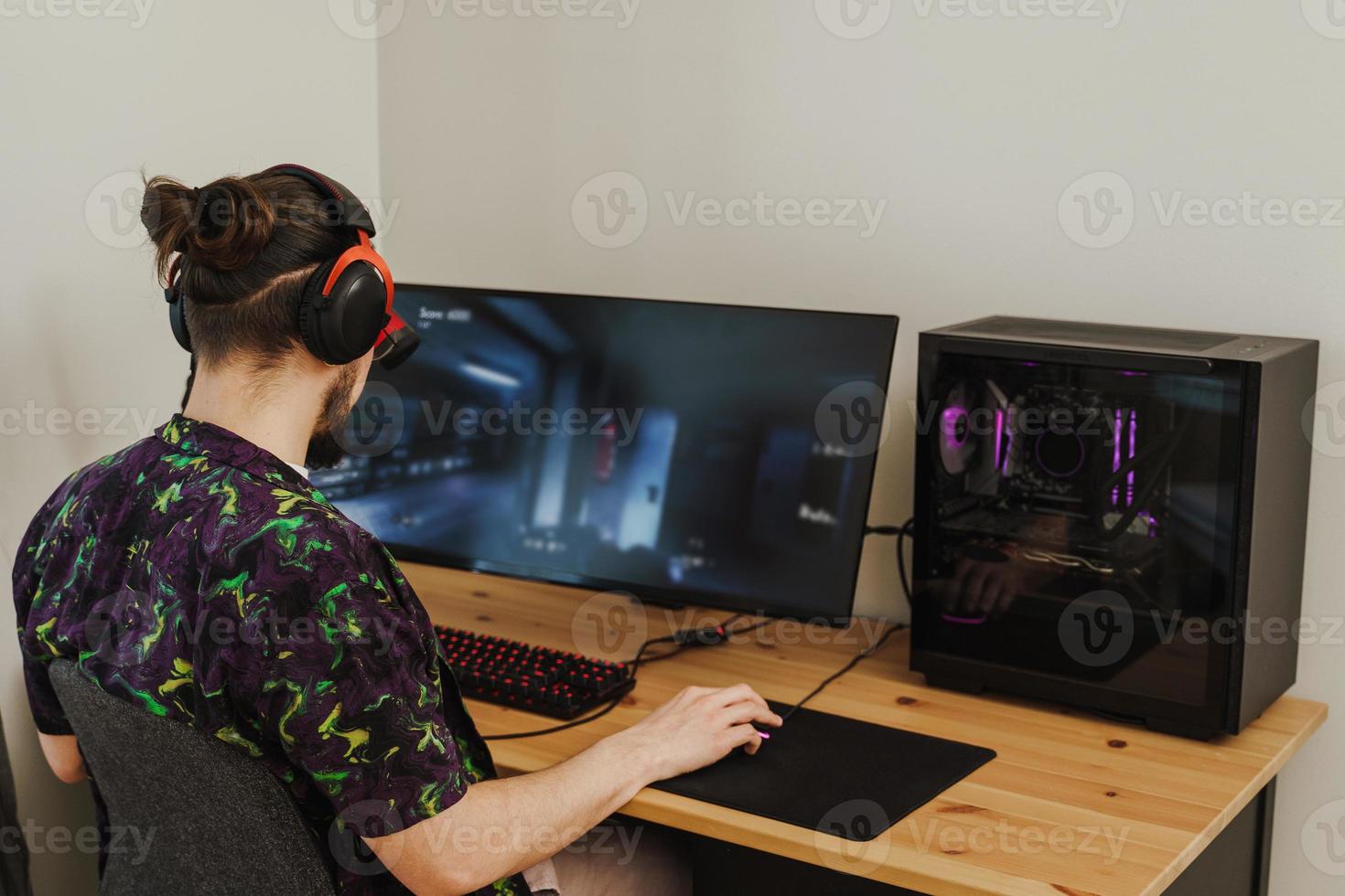 Young man gamer playing video game on his modern personal computer photo