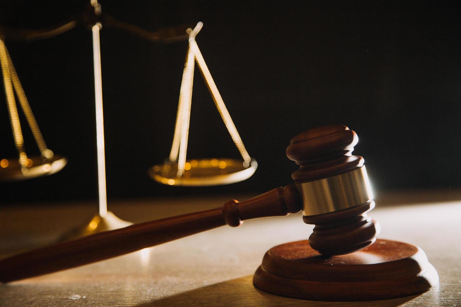Business and lawyers discussing contract papers with brass scale on desk in office. Law, legal services, advice, justice and law concept picture with film grain effect photo