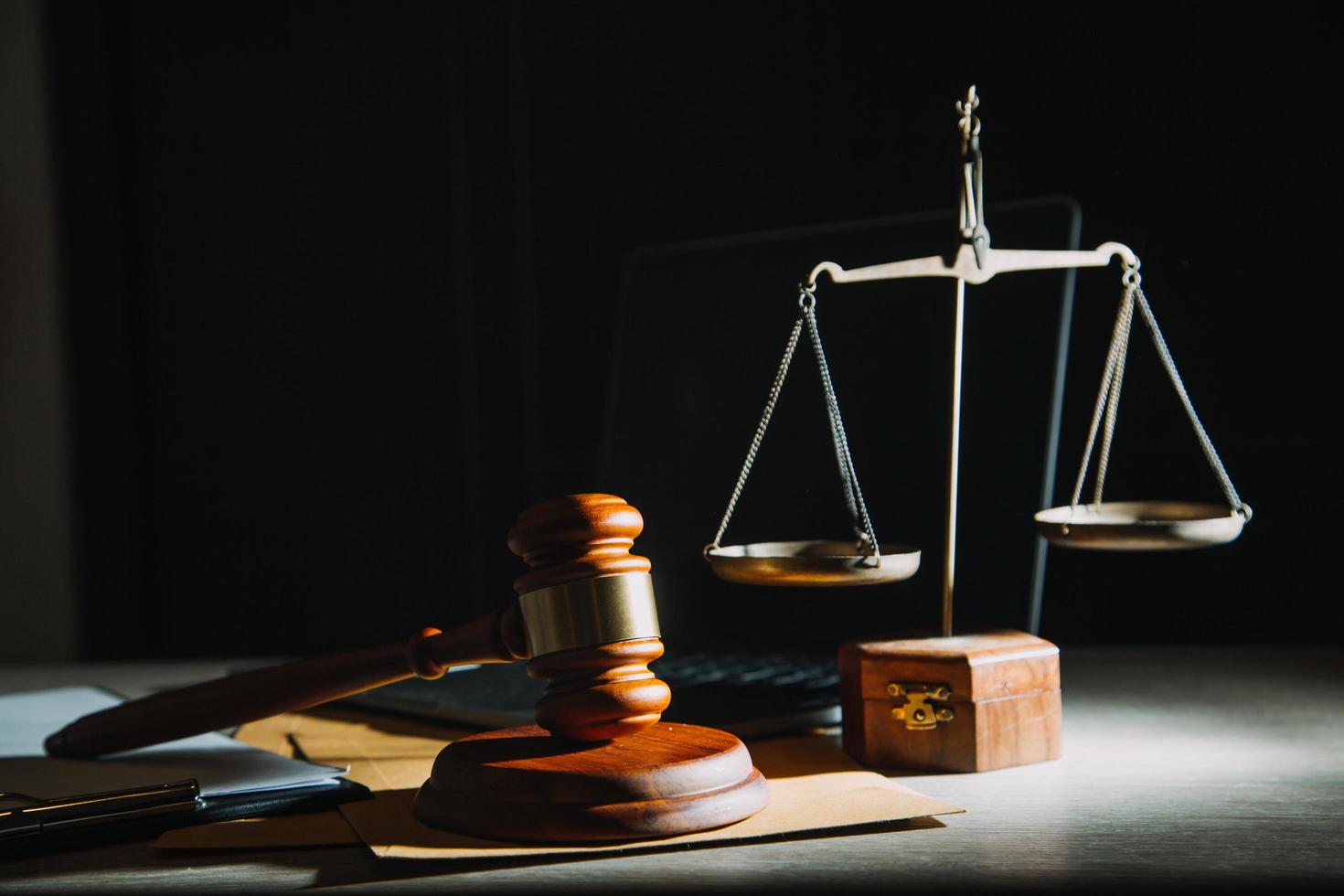 Business and lawyers discussing contract papers with brass scale on desk in office. Law, legal services, advice, justice and law concept picture with film grain effect photo