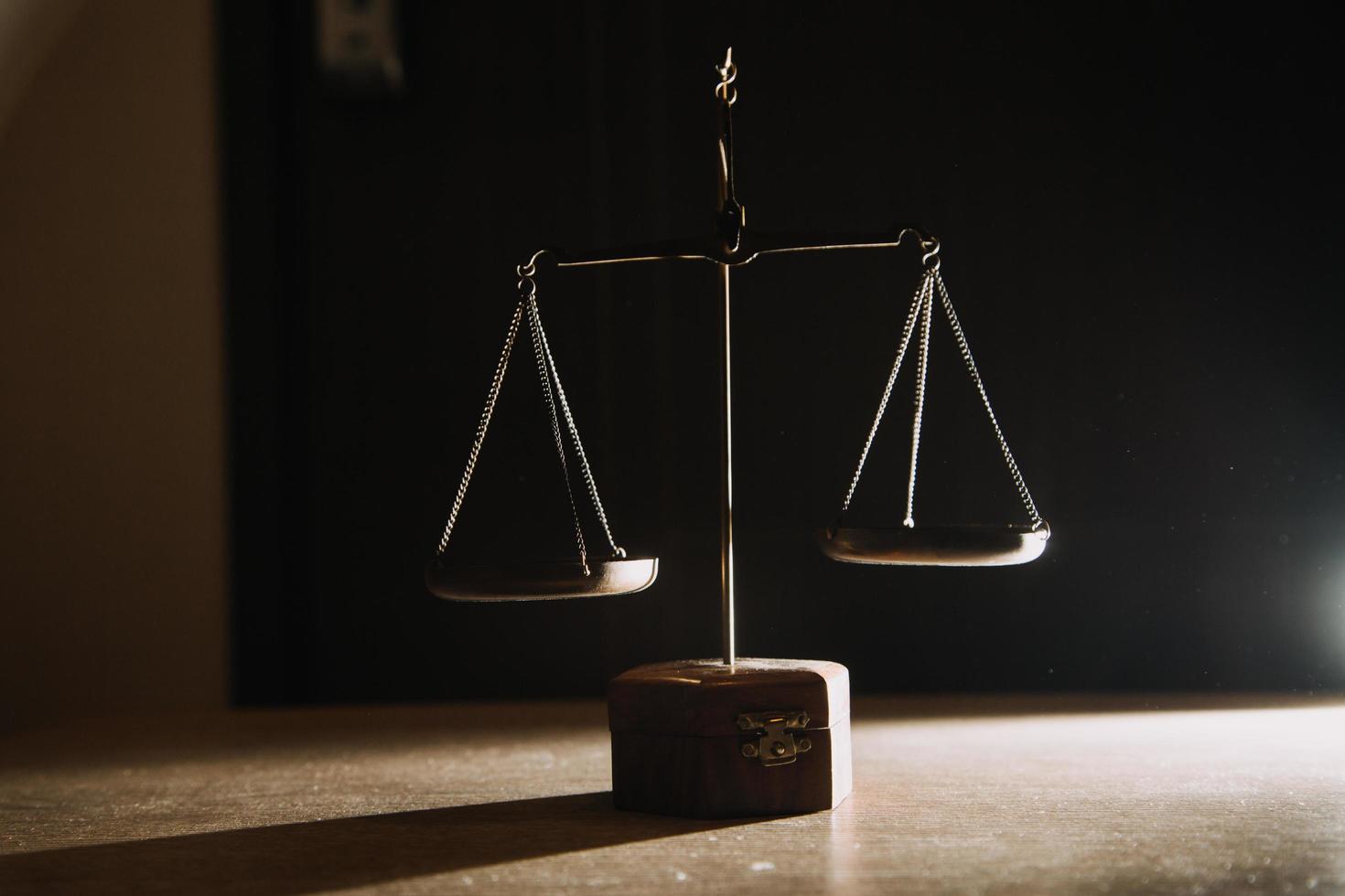 Business and lawyers discussing contract papers with brass scale on desk in office. Law, legal services, advice, justice and law concept picture with film grain effect photo