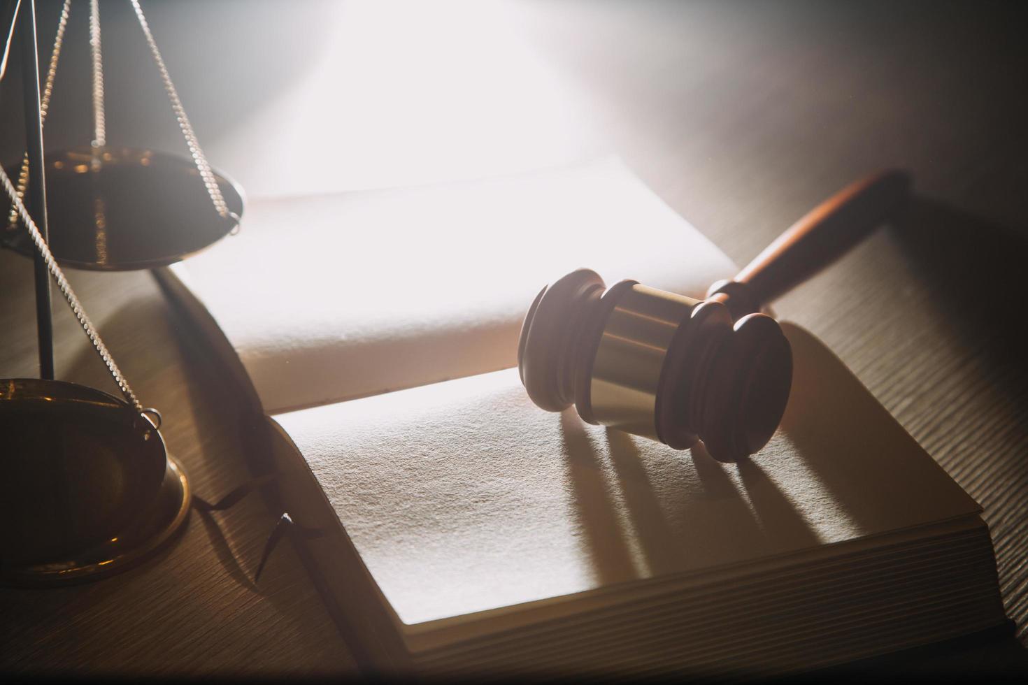 Business and lawyers discussing contract papers with brass scale on desk in office. Law, legal services, advice, justice and law concept picture with film grain effect photo