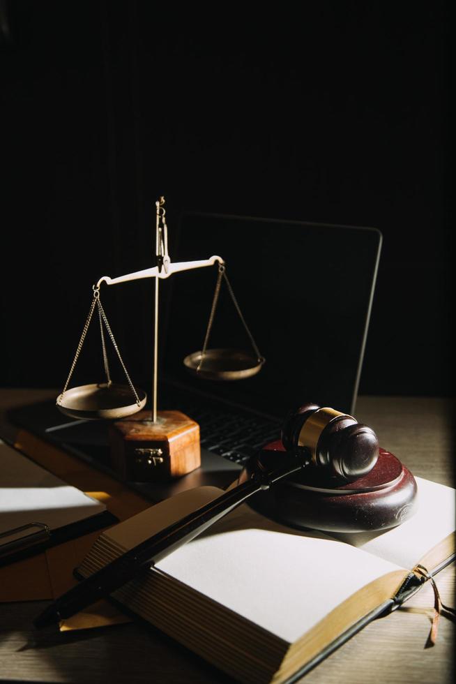 Business and lawyers discussing contract papers with brass scale on desk in office. Law, legal services, advice, justice and law concept picture with film grain effect photo