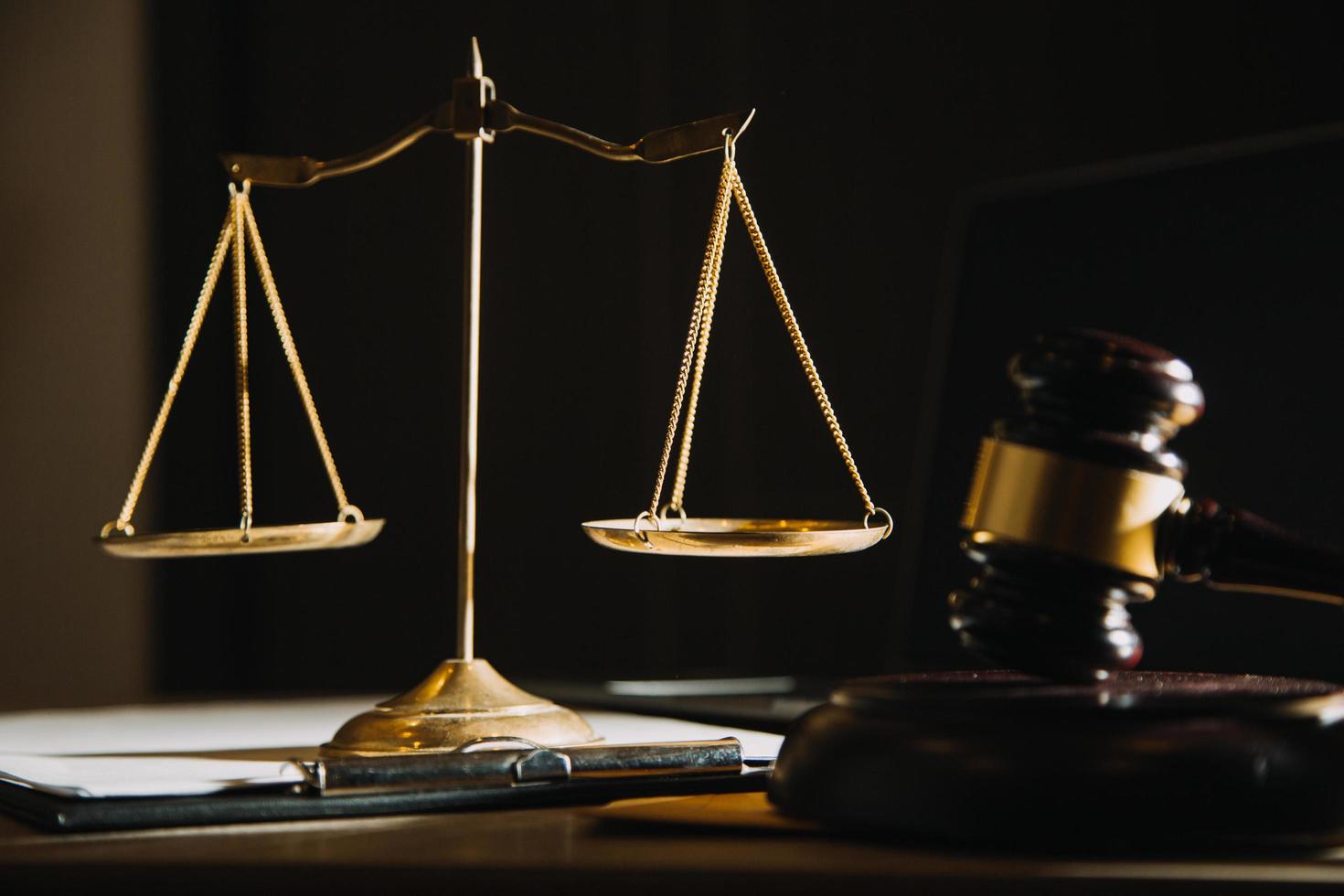 Business and lawyers discussing contract papers with brass scale on desk in office. Law, legal services, advice, justice and law concept picture with film grain effect photo