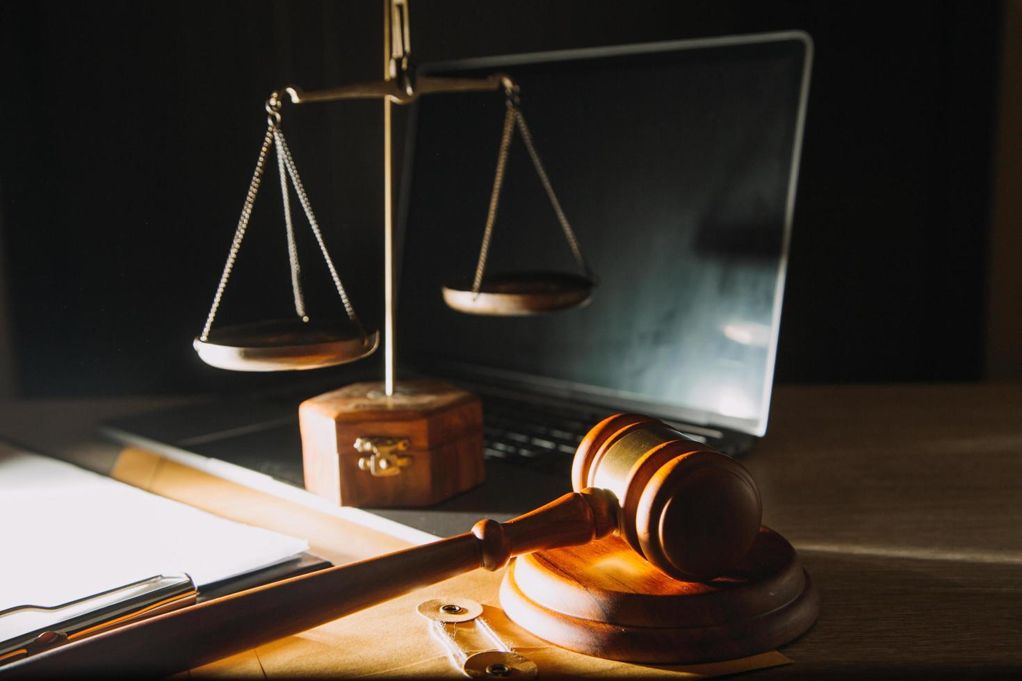 Business and lawyers discussing contract papers with brass scale on desk in office. Law, legal services, advice, justice and law concept picture with film grain effect photo