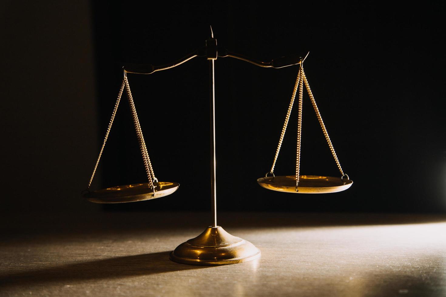 Business and lawyers discussing contract papers with brass scale on desk in office. Law, legal services, advice, justice and law concept picture with film grain effect photo