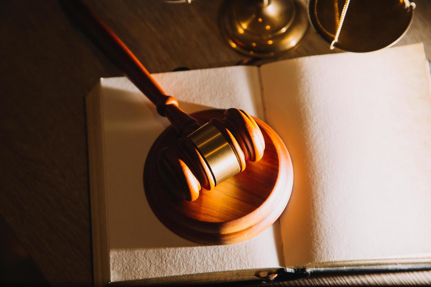 Business and lawyers discussing contract papers with brass scale on desk in office. Law, legal services, advice, justice and law concept picture with film grain effect photo
