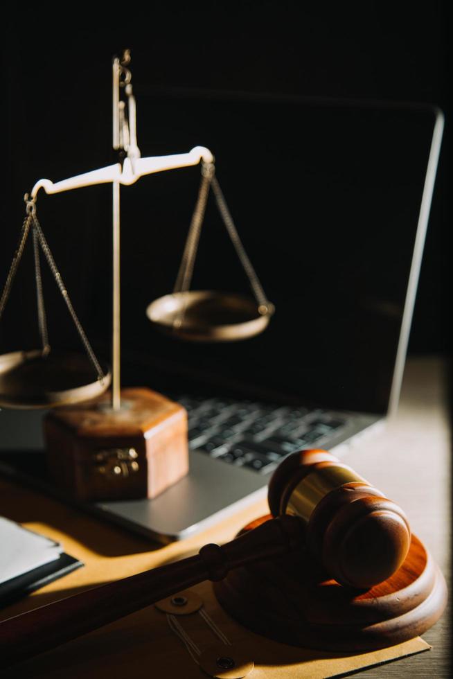 Business and lawyers discussing contract papers with brass scale on desk in office. Law, legal services, advice, justice and law concept picture with film grain effect photo