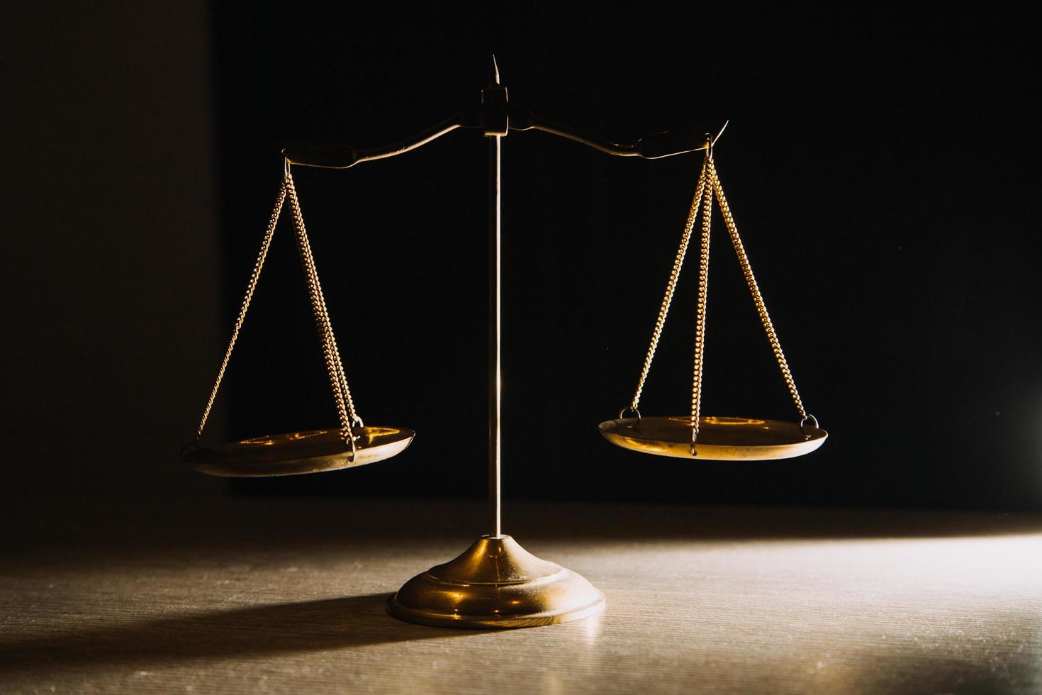 Business and lawyers discussing contract papers with brass scale on desk in office. Law, legal services, advice, justice and law concept picture with film grain effect photo