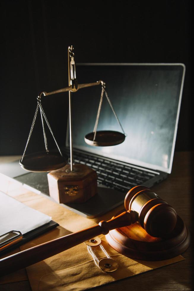 Business and lawyers discussing contract papers with brass scale on desk in office. Law, legal services, advice, justice and law concept picture with film grain effect photo