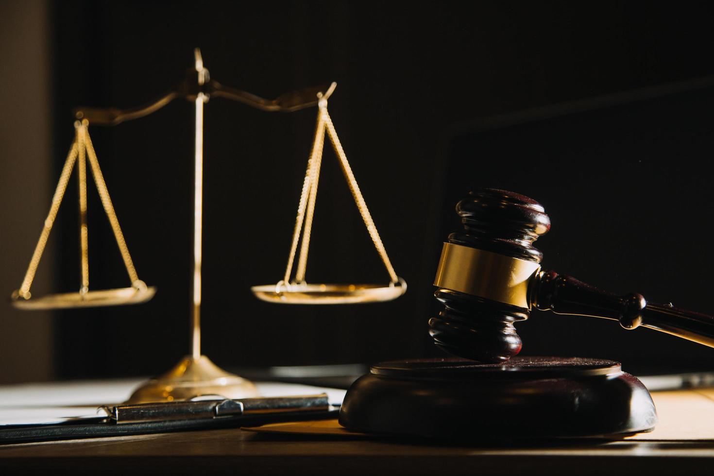 Business and lawyers discussing contract papers with brass scale on desk in office. Law, legal services, advice, justice and law concept picture with film grain effect photo