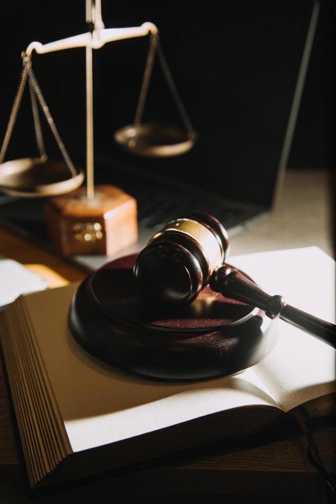 Business and lawyers discussing contract papers with brass scale on desk in office. Law, legal services, advice, justice and law concept picture with film grain effect photo