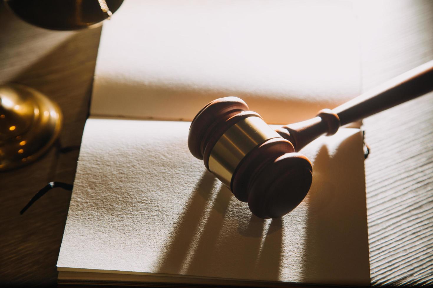 Business and lawyers discussing contract papers with brass scale on desk in office. Law, legal services, advice, justice and law concept picture with film grain effect photo