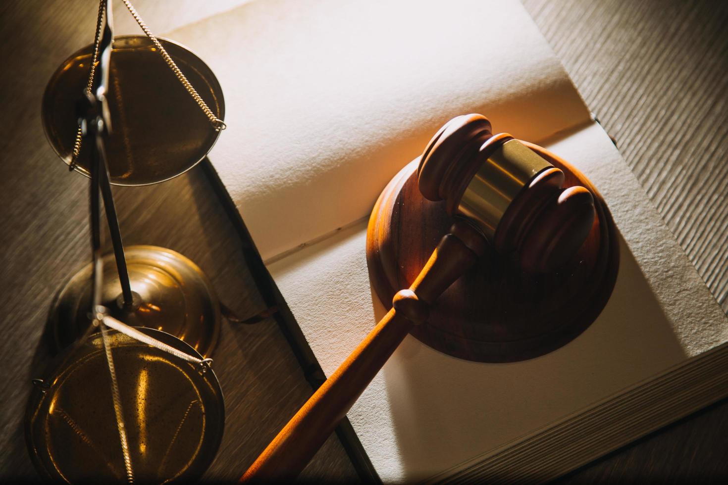 Business and lawyers discussing contract papers with brass scale on desk in office. Law, legal services, advice, justice and law concept picture with film grain effect photo