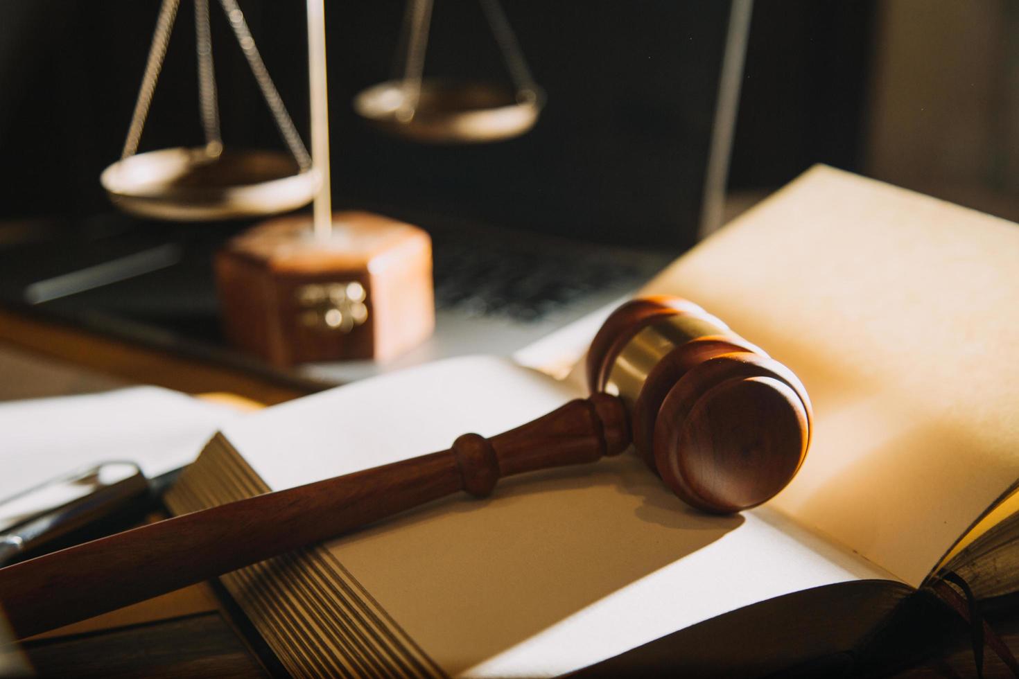 Business and lawyers discussing contract papers with brass scale on desk in office. Law, legal services, advice, justice and law concept picture with film grain effect photo