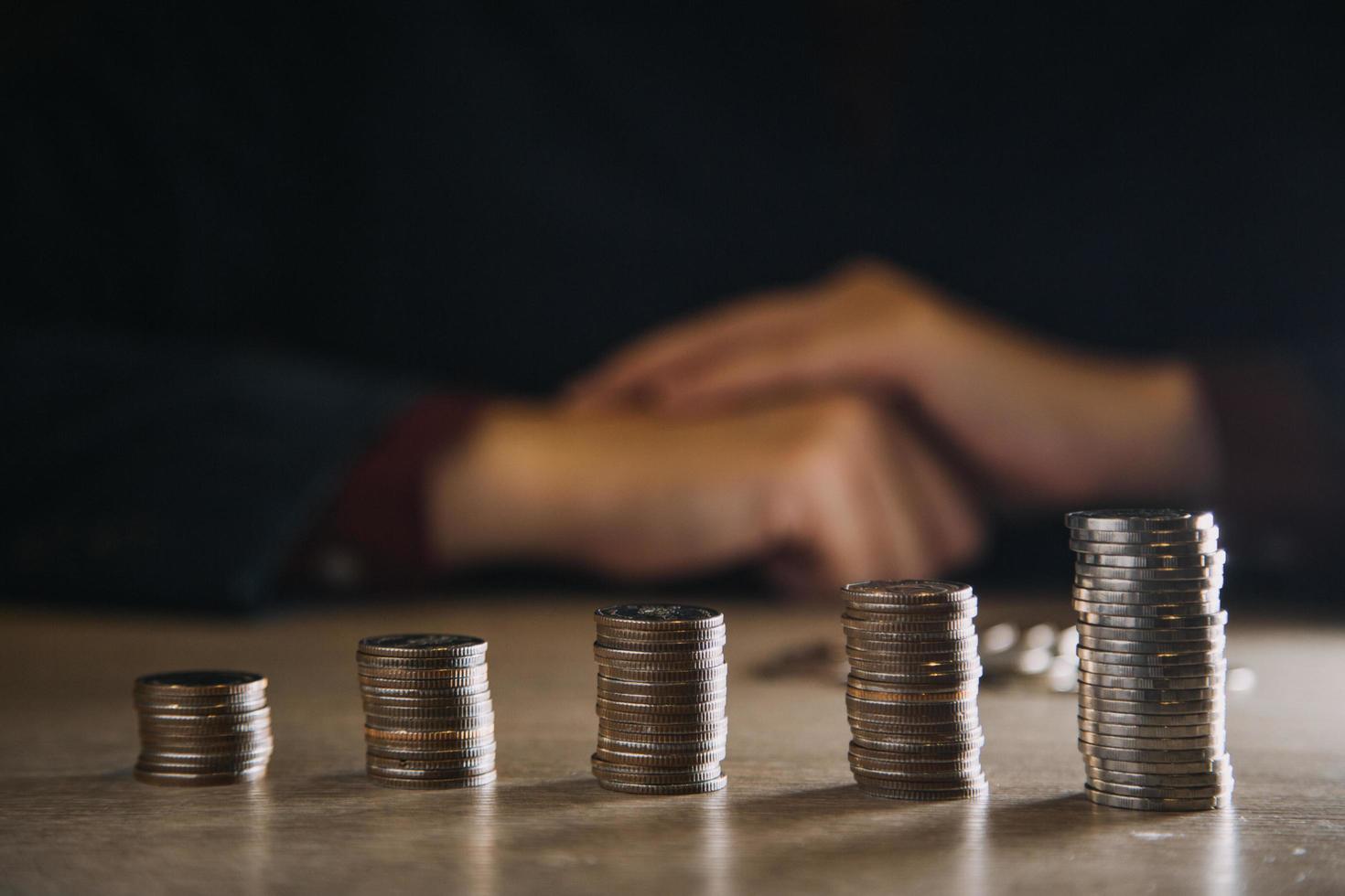 business woman hand calculating her money in the end of month with coin, calculator and calendar on wooden table photo