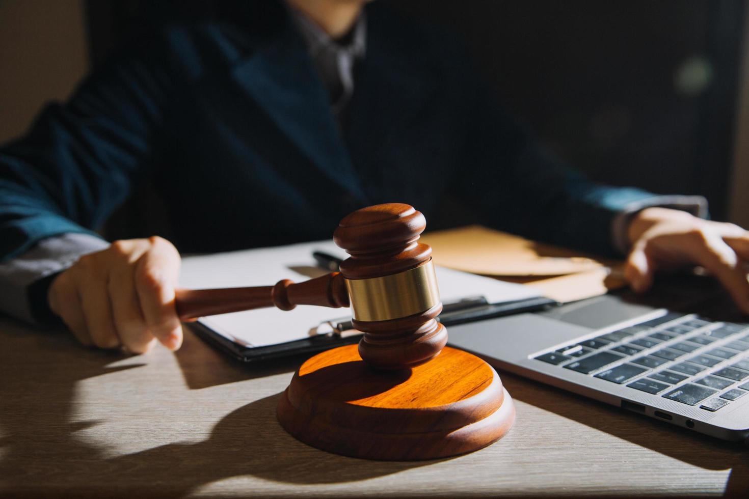 Business and lawyers discussing contract papers with brass scale on desk in office. Law, legal services, advice, justice and law concept picture with film grain effect photo