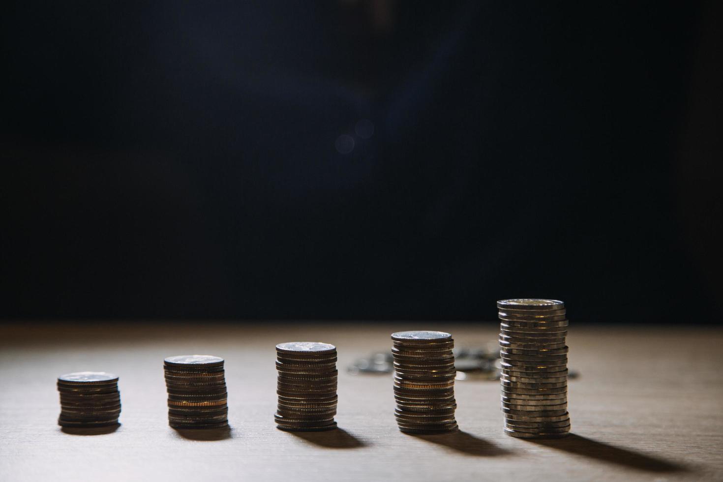 business woman hand calculating her money in the end of month with coin, calculator and calendar on wooden table photo