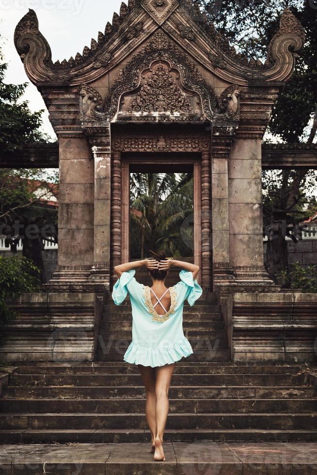 Young woman posing beside ancient Khmer ruins photo