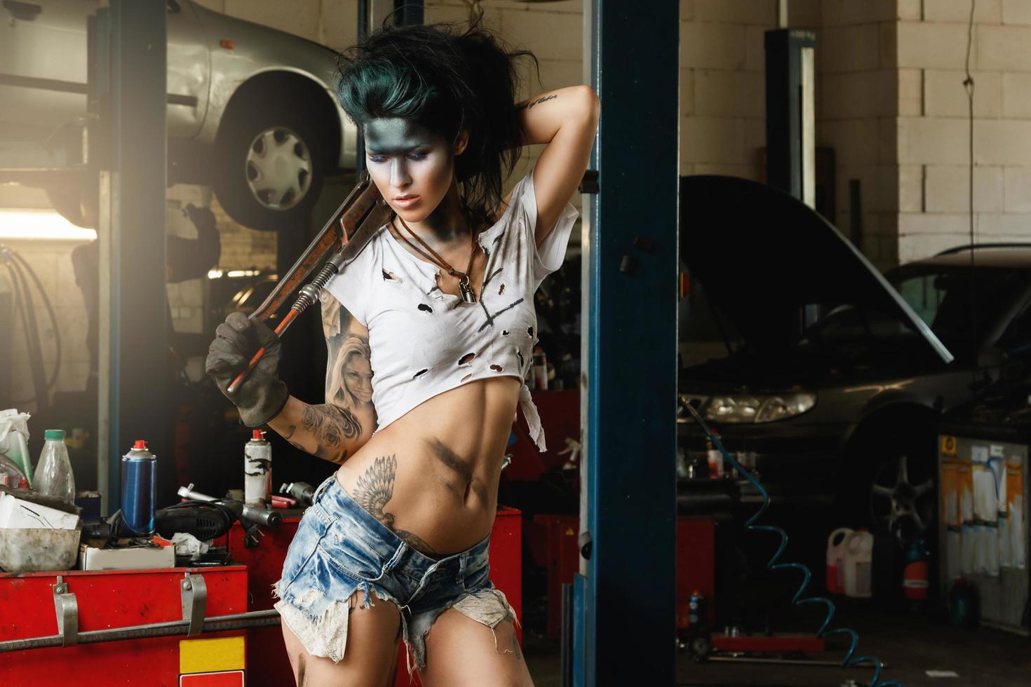 Female mechanic in the garage with artistic makeup on her face stylized like a dirty spot photo