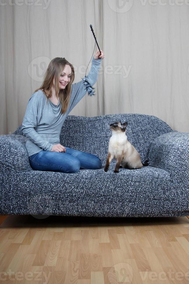 young woman playing with cat photo