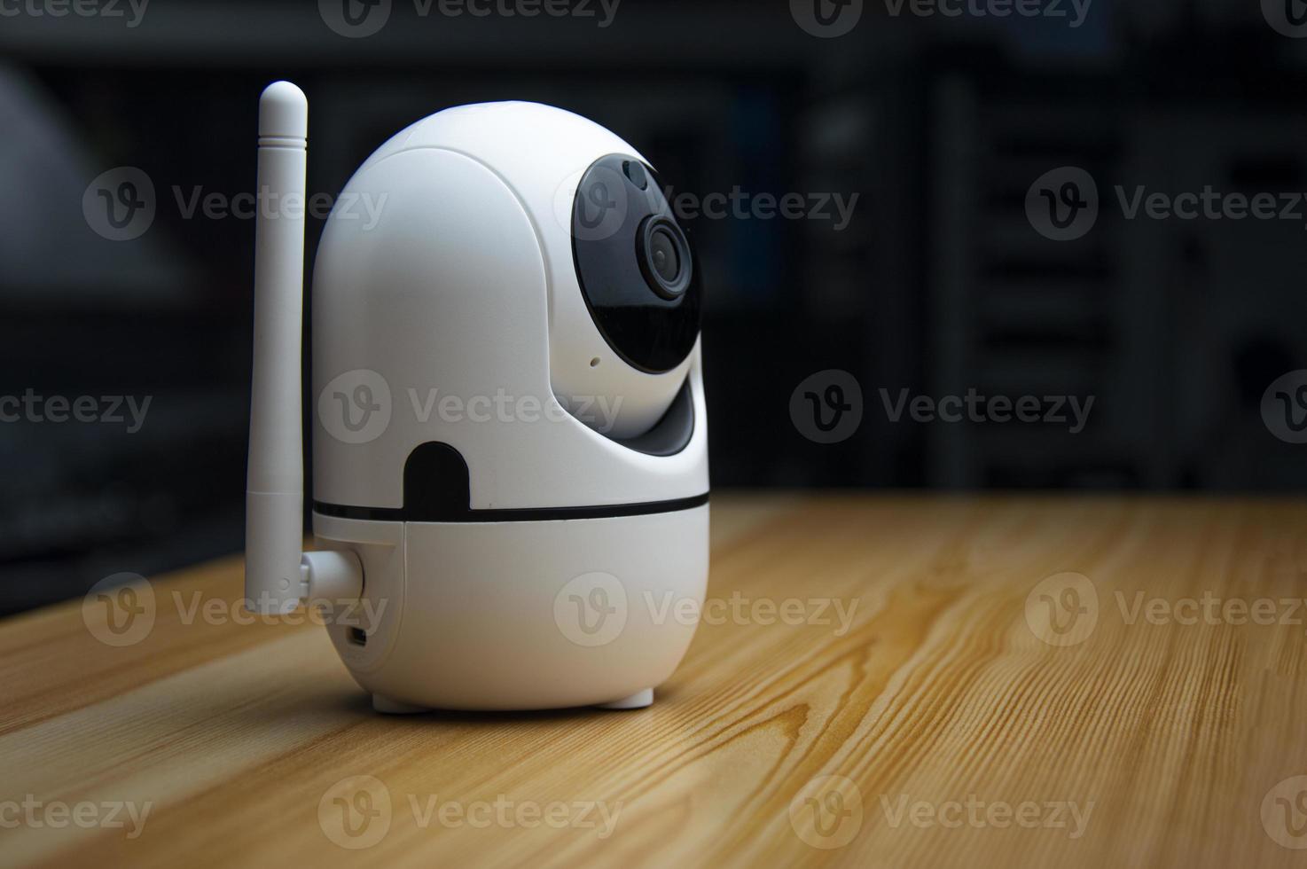 White IP camera placed on wooden floor photo