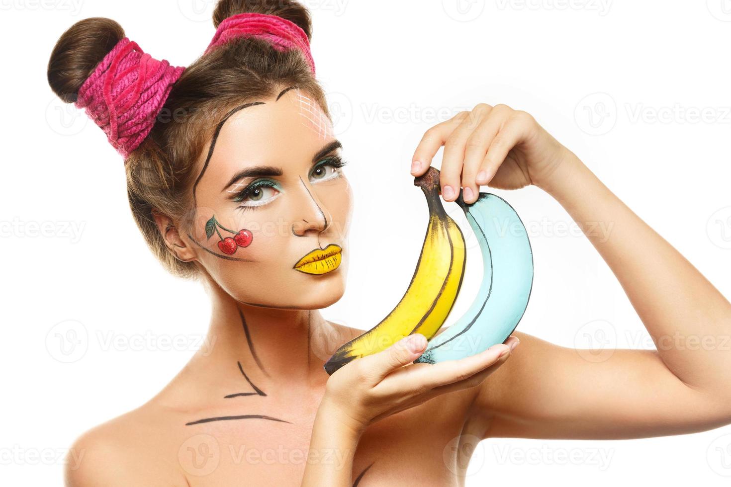 hermosa modelo con maquillaje creativo de arte pop sosteniendo plátanos foto