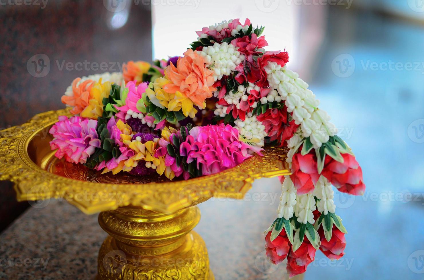 Jasmine and rose garland on golden pedestal photo