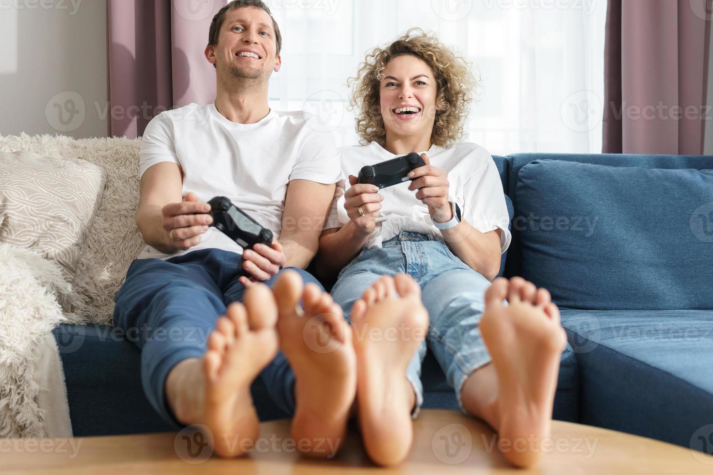 Couple with a gamepads are playing video game console at home photo