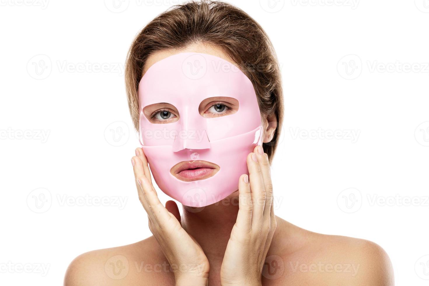 Young beautiful woman with rubber facial mask on her face photo