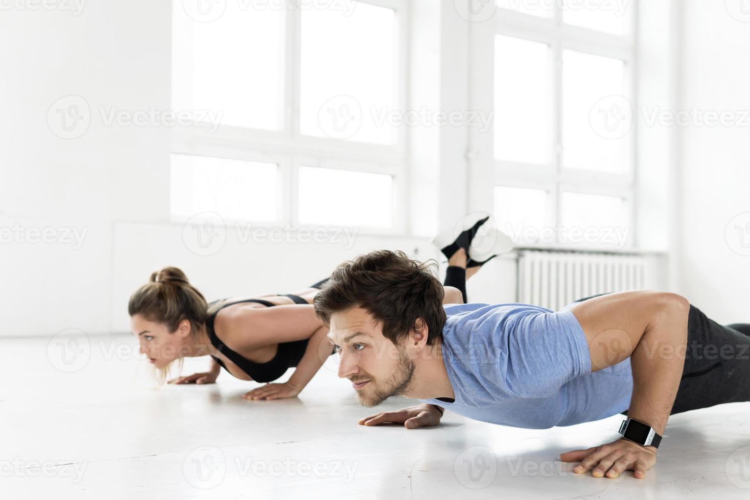 Fitness man and woman during workout with in the gym photo