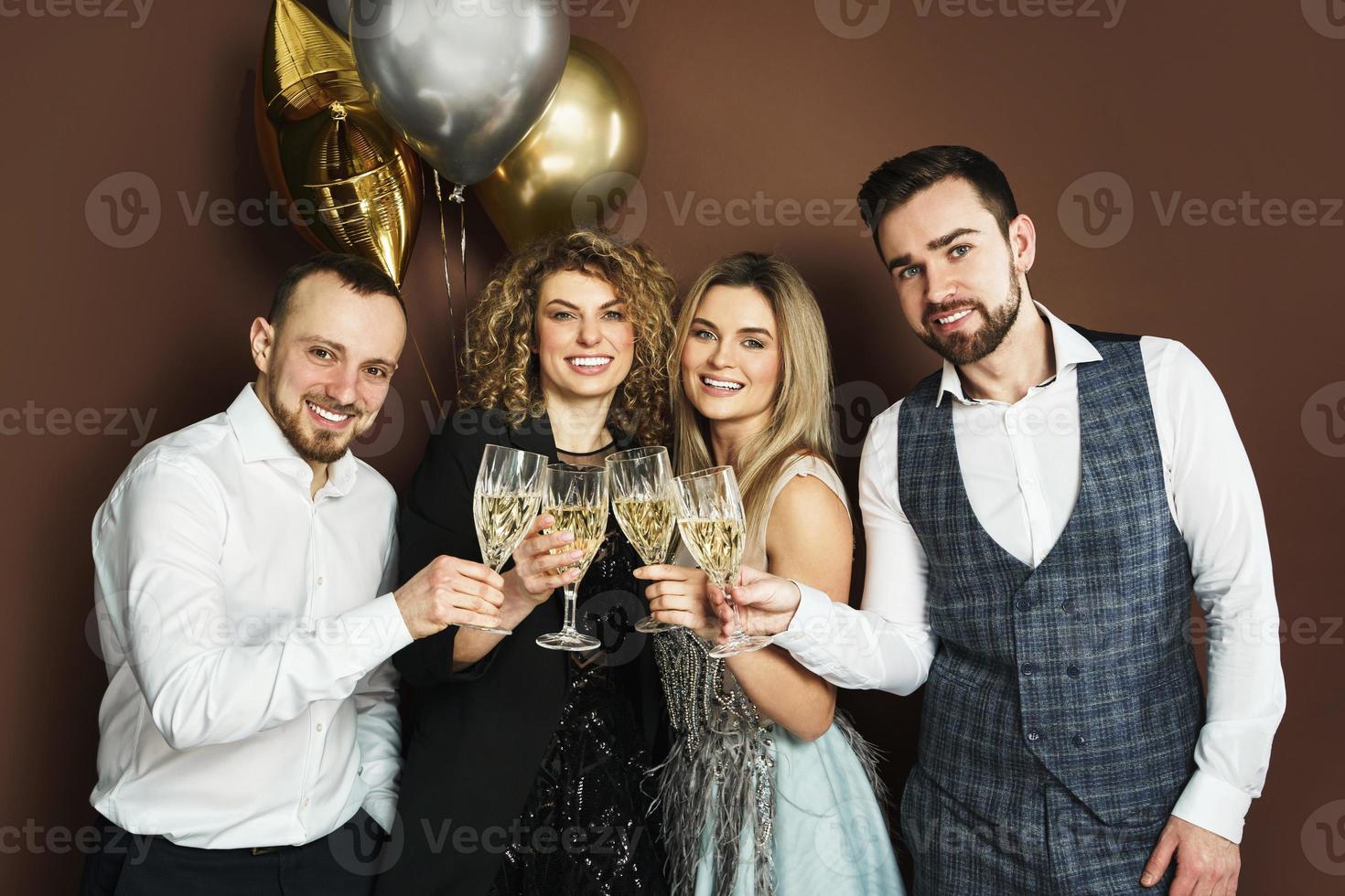 Well dressed party people celebrating  holiday or event and drinking sparkling wine photo