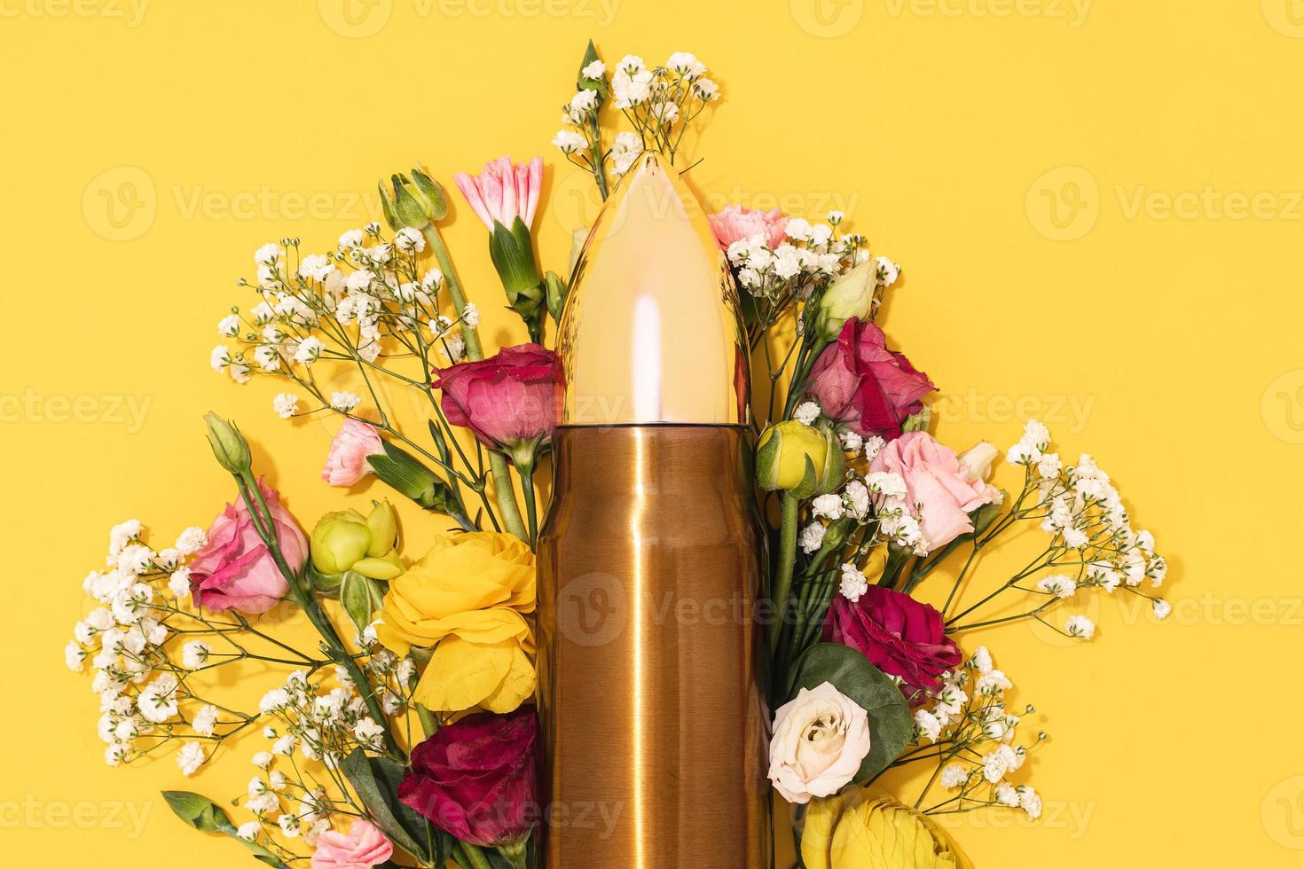 Pacifism and non-violence movement. Bullet and bunch of different flowers against yellow background. photo