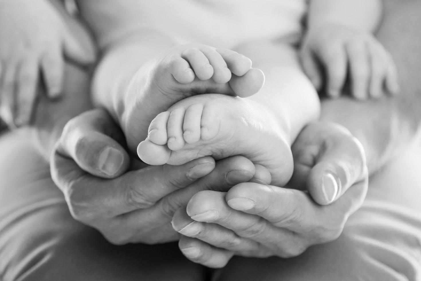 Father's hands holding feet of his baby photo