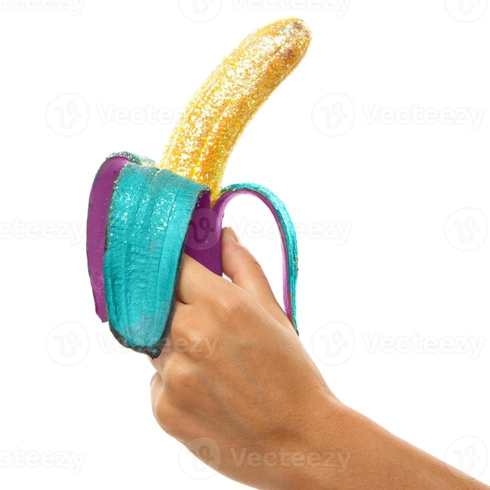 Female hands and banana covered with a colorful glitters photo