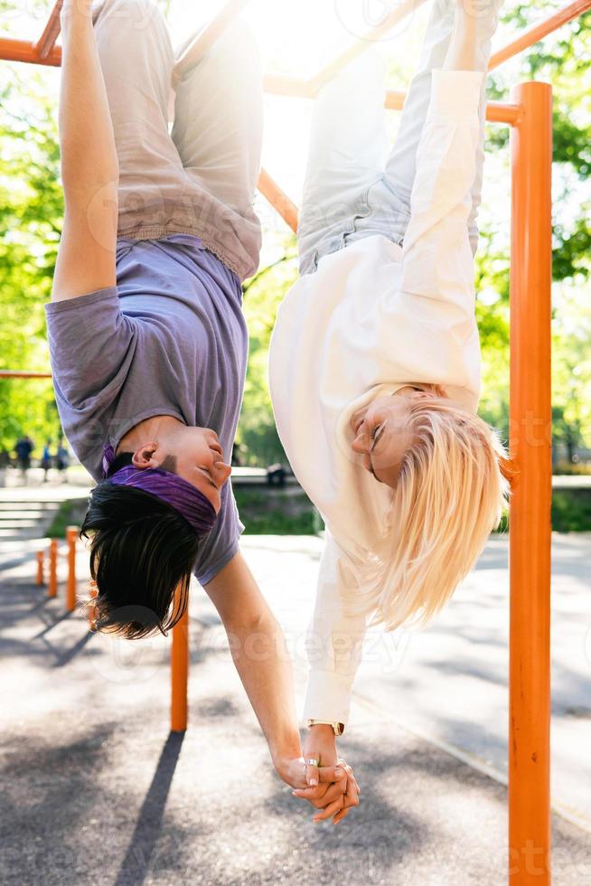Happy teen couple having fun on playground in a city park photo