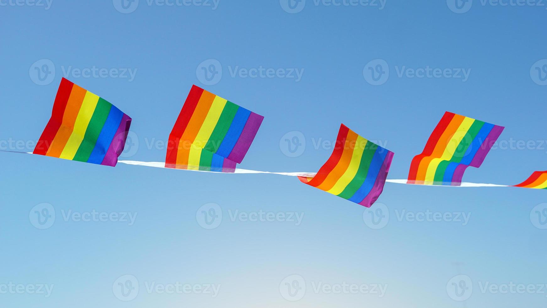 LGBT flag on blue sky background, it is a symbol of lesbian, gay, bisexual, and transgender  pride and LGBT social movements. Also known as the gay pride flag or LGBT. photo