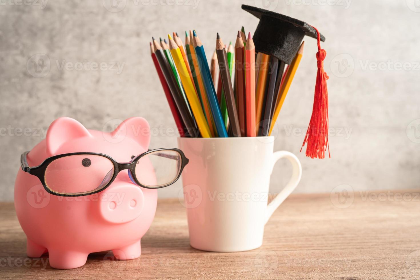 Pigging bank wearing eyeglass with colorful pencils photo