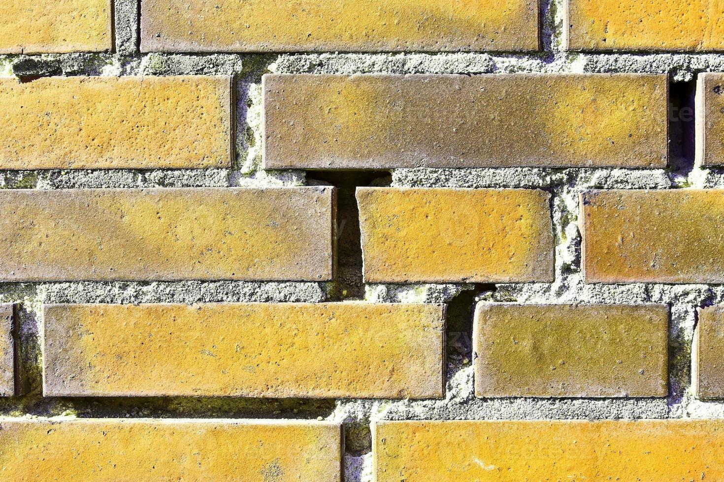 Detailed view at a colorful old and weathered brick wall texture as a panoramic background. photo