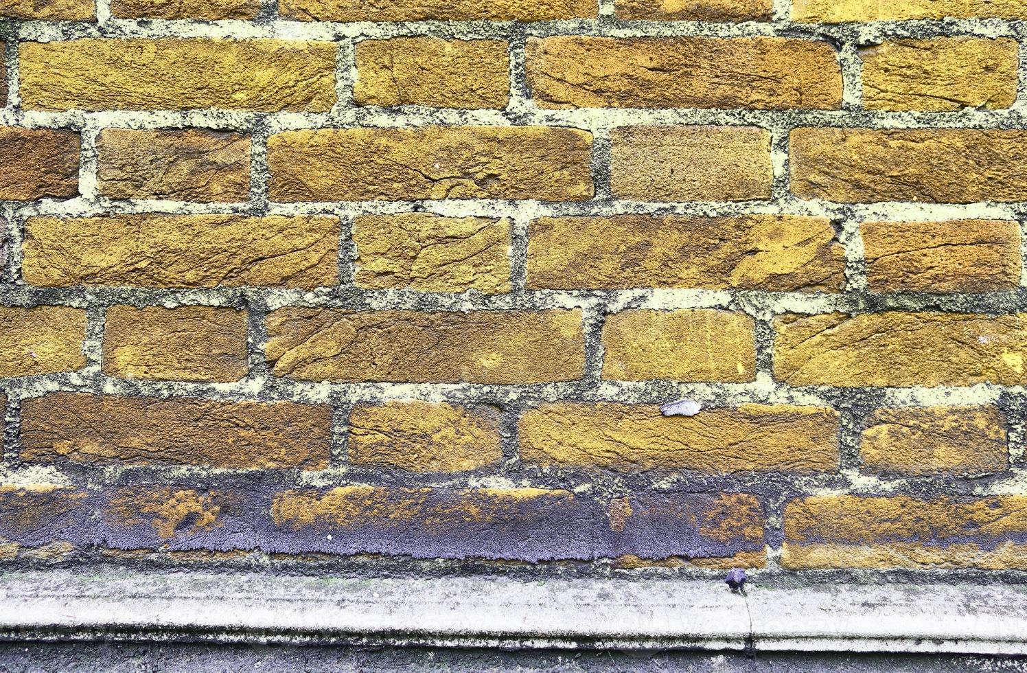 Detailed view at a colorful old and weathered brick wall texture as a panoramic background. photo