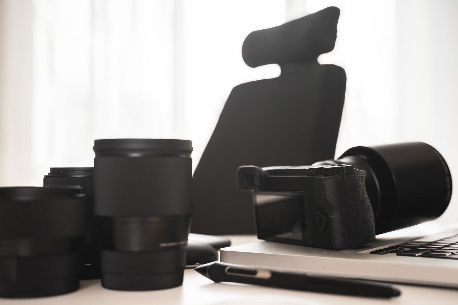 Workplace with a modern equipment for photography. Mirrorless camera and prime lenses. photo