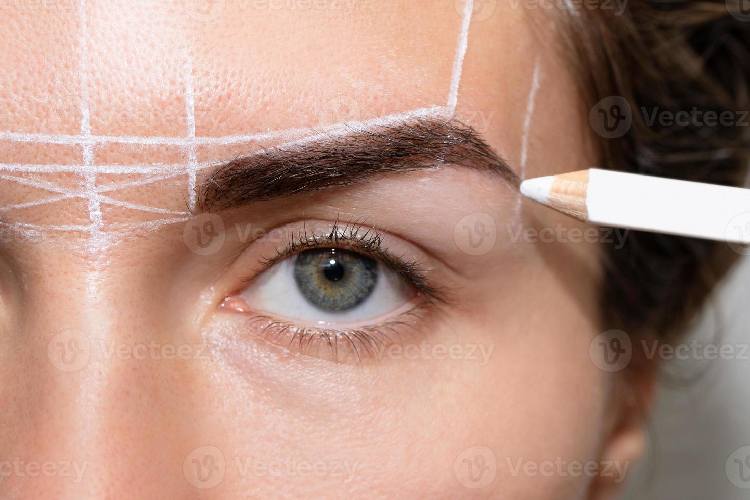 Woman during professional eyebrow mapping procedure photo