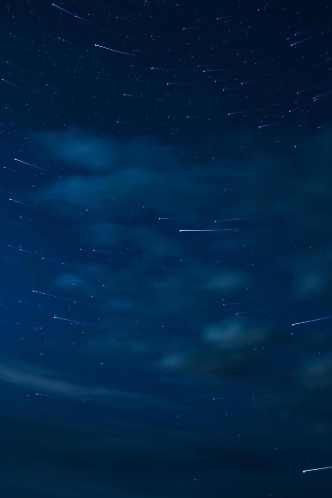 cielo nocturno con estrellas y nubes en movimiento foto